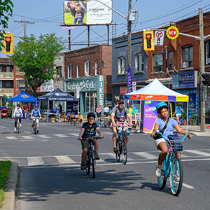 Group of adults and child riding bicycles on King Street during Open Street Event