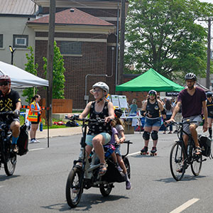 People riding bicycles, roller skating down closed street during Open Street Event