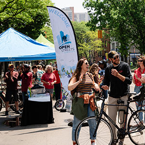 People standing near and visiting Open Streets Booth