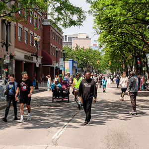 Groups of people walking and biking along closed street during Open Streets event in May 2024