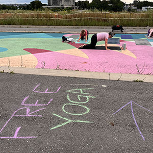 Group of people doing free yoga in closed street at Mini Open Streets at Pier 8 