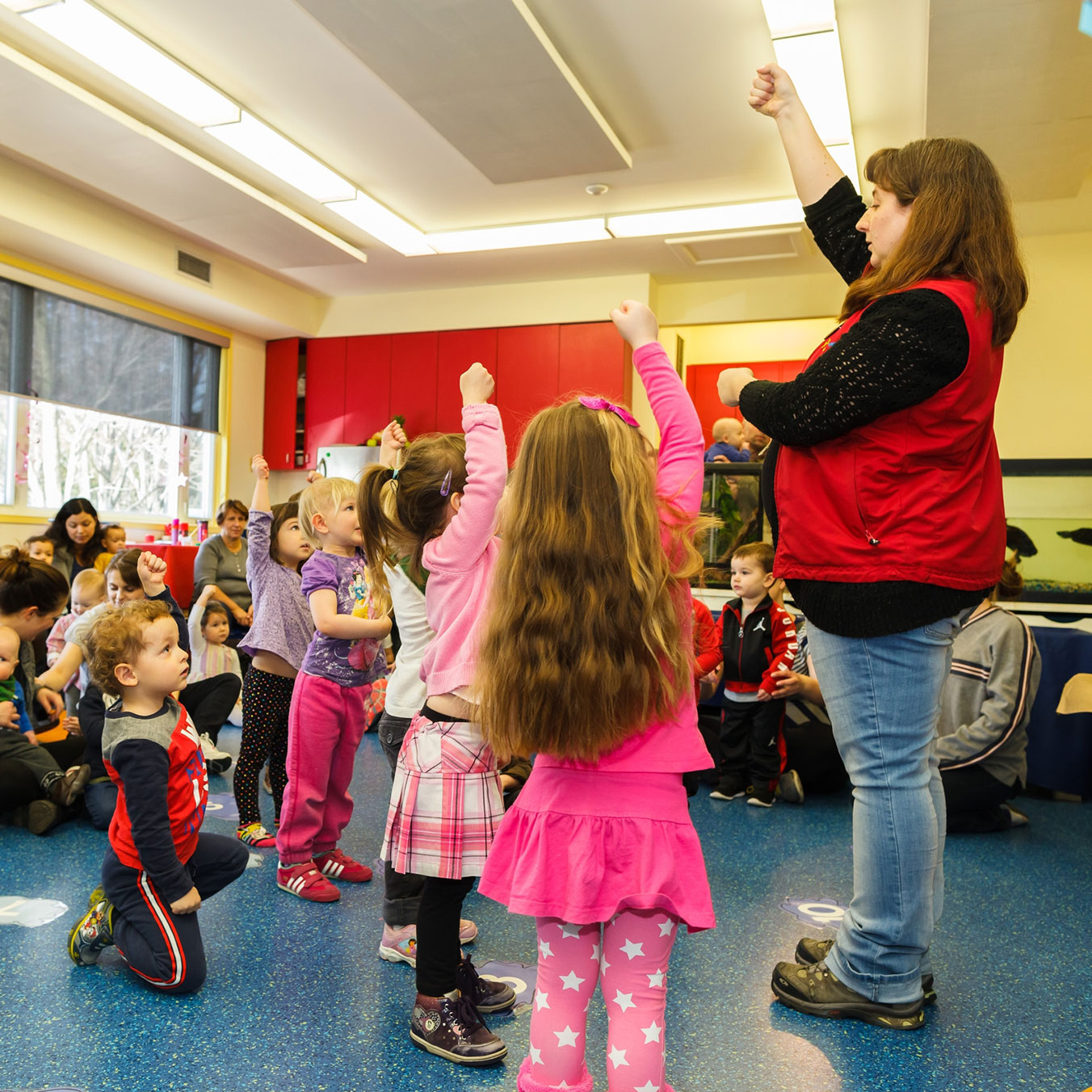 Group of children following museum leader instruction