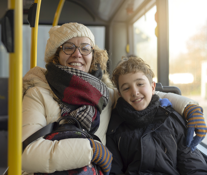 woman and child sitting on a bus dressed for winter