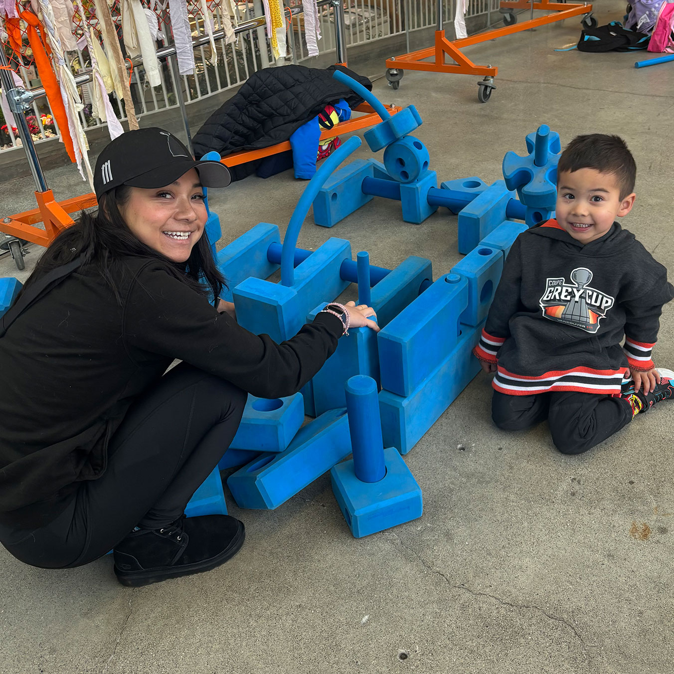 women and child playing with large blue blocks at Hamilton Farmer's Market