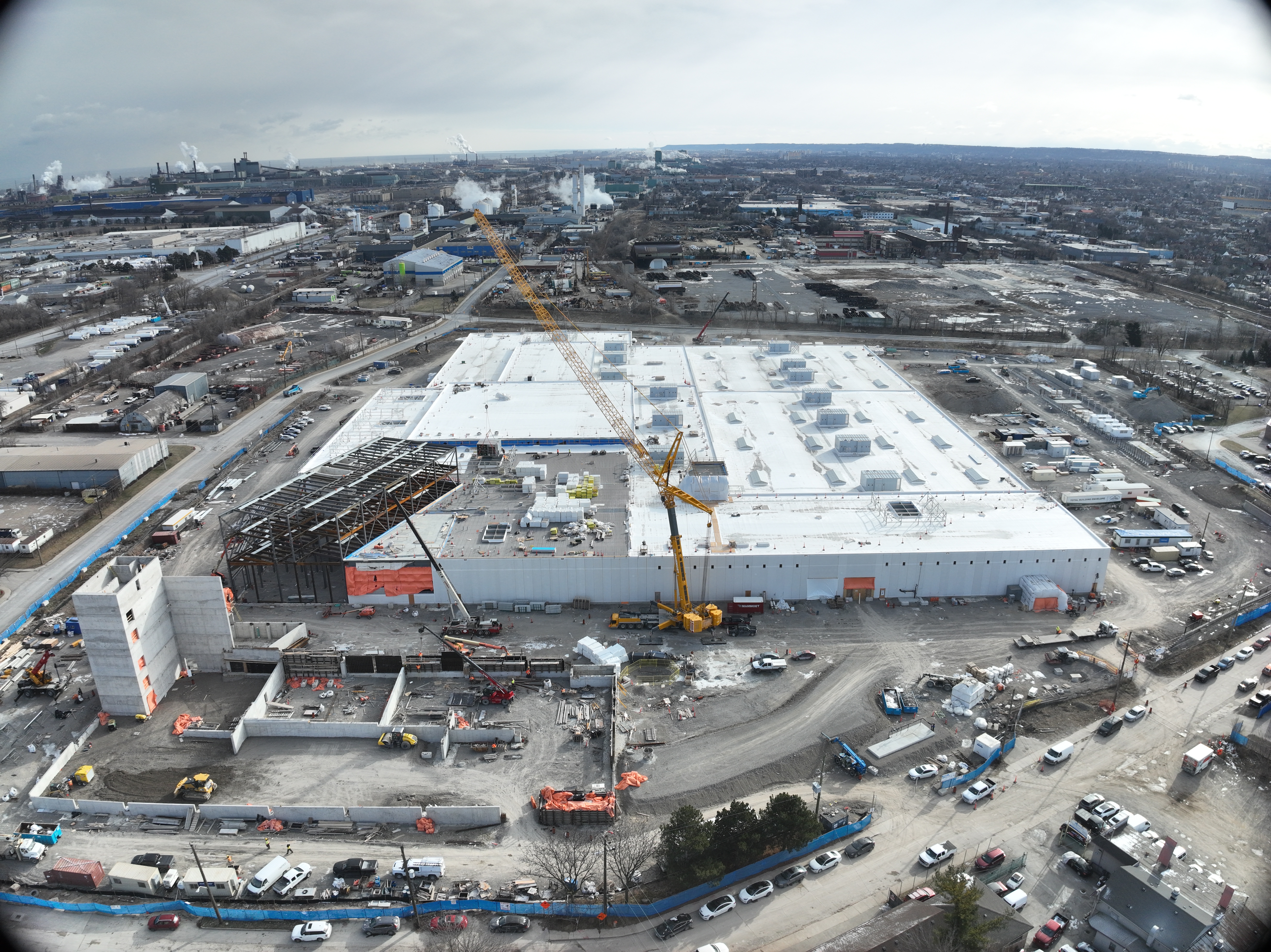 View looking east from Hillyard Street. The structural steel of the elevated administration building has commenced, and the elevator shaft for the parking structure is complete.