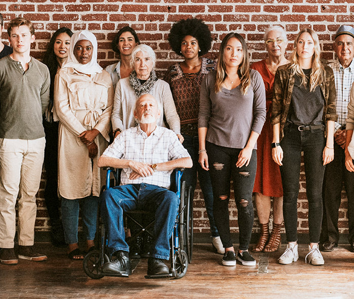 group of people standing in front of a brick wall