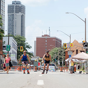 People rollarblading, walking and tents sent up for June 2025 Open Streets Event