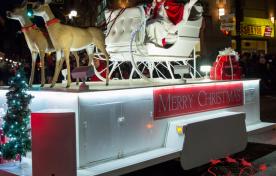 Mrs. Claus sitting in a sleigh pulled by reindeer - Santa Claus Parade float