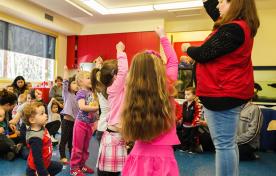 Group of children following museum leader instruction