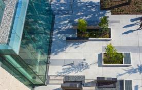 Top view of outdoor approach to David Braley building with trees and gardens