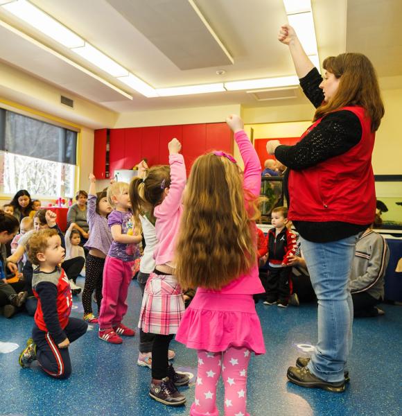 Group of children following museum leader instruction