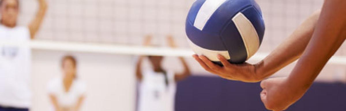 Person about to serve a volleyball during a game