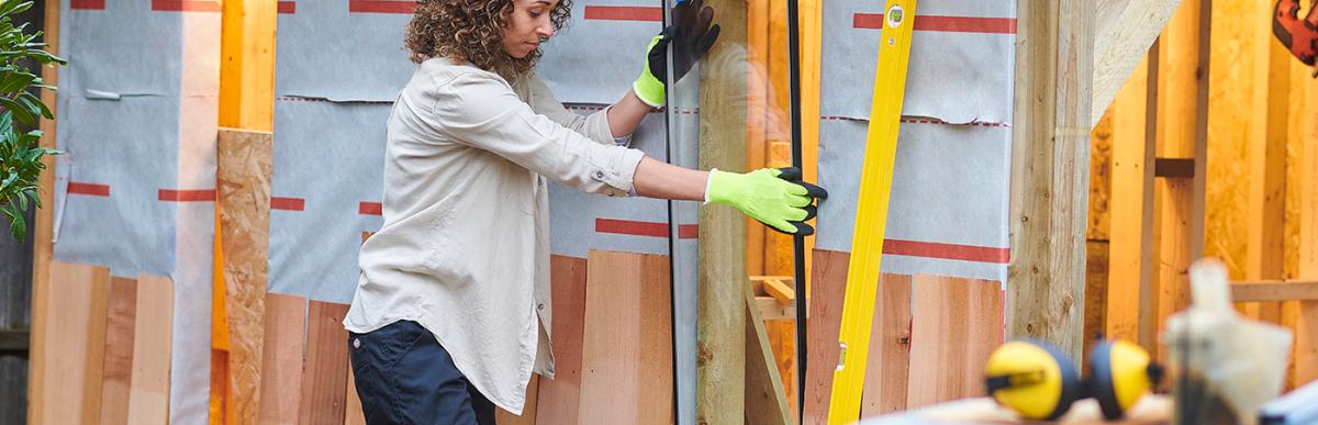 Women building a detached shed in backyard