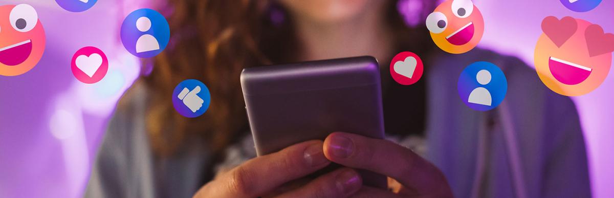 Happy young woman using her phone to interact with social media, getting followers, likes, emoji feedback