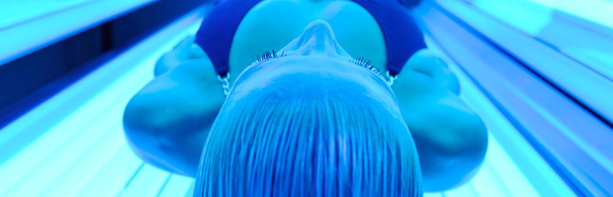 Young woman laying in a tanning bed