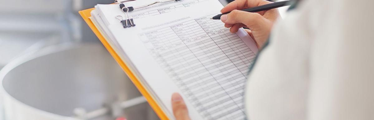 Woman inspector with checklist in a restaurant kitchen