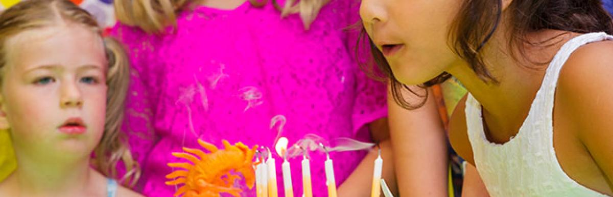 Children blowing out candles on a birthday cake