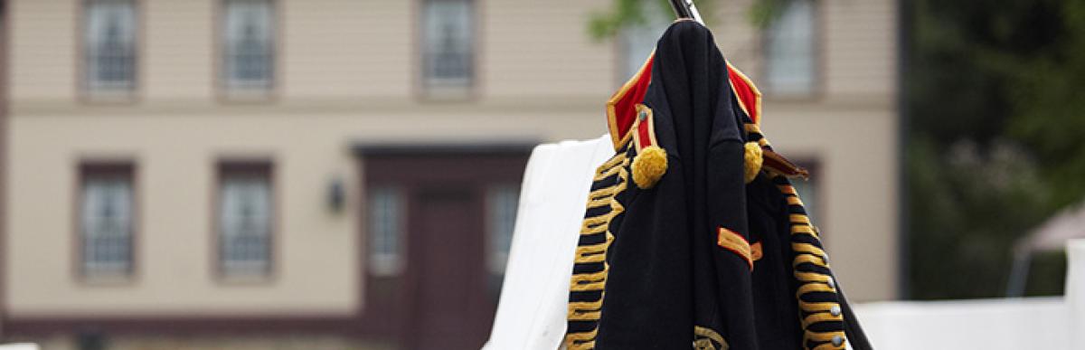 Re-enactment Period Coat and weapon leaning on canvas tent