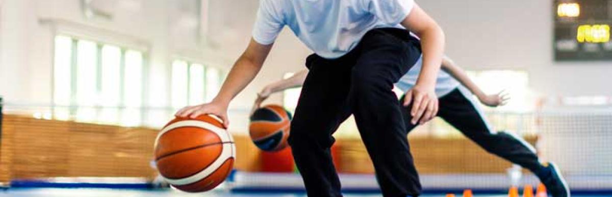 young boy playing basketball in a gym