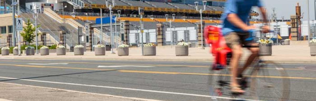 Person on a bike riding past Tim Horton's Field