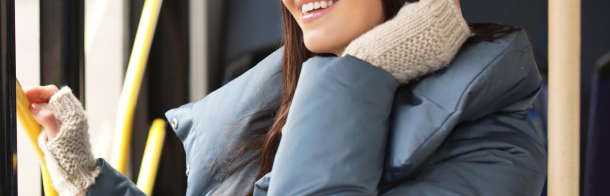 Women on a bus in parka and toque wearing headphones