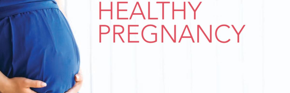 Pregnant woman in a blue dress on a white background