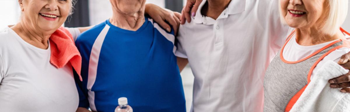 Four older people in gym clothes smiling at the camera