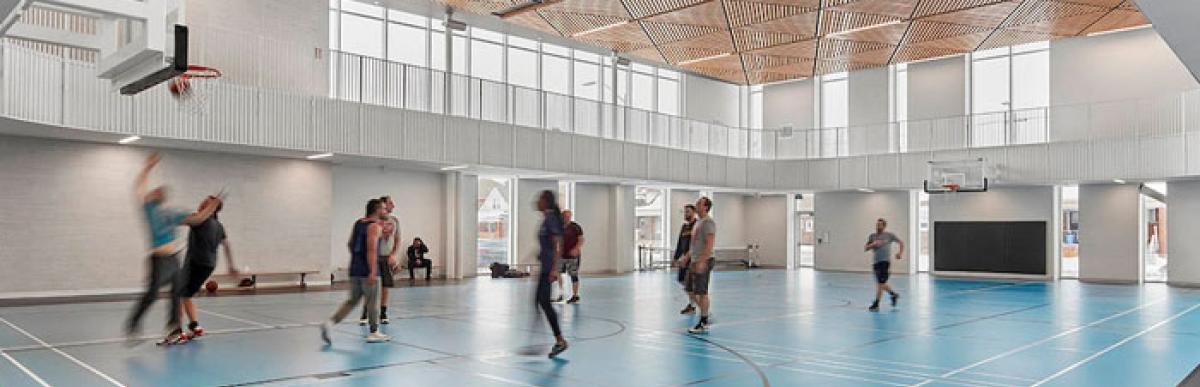 Several people playing basketball in the indoor gym at Bernie Morelli Recreation Centre