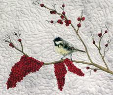 stiched design on a blanket of bird on a tree branch