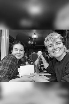 black and white photo of 2 people sitting at a restaurant table